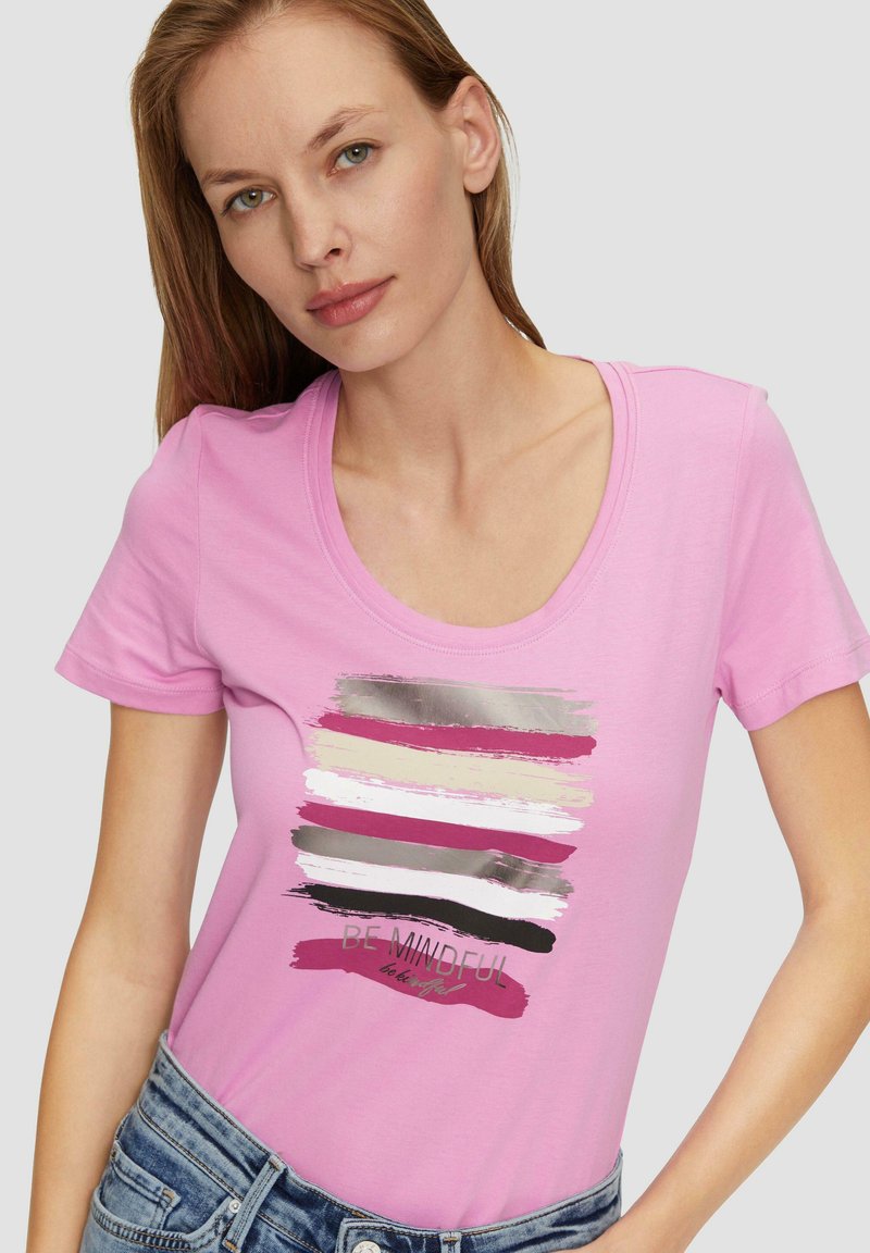 T-shirt rose à manches courtes avec un décolleté en scoop et un design graphique avec des coups de pinceau multicolores et le texte "SOIS ATTENTIF."