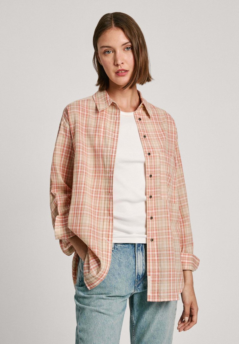 Geruite shirt in perzik, beige en wit. Heeft een ontspannen fit, een enkele borstzak en een knoopsluiting aan de voorkant. Lichtgewicht stof.