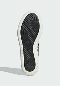 Suola di scarpa in gomma nera con motivi geometrici in rilievo, bordata da un rinforzo bianco. La superficie è testurizzata per garantire aderenza e durata.