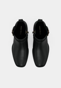 Melnas ādas potīšu zābakus ar kvadrātveida purngaliem un sānu sprādzēm, skatīti no augšas uz vienkrāsaina baltā fona.