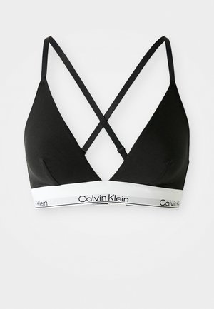 Svart bomullstriangle bralette med tynne justerbare stropper som krysser bak. Har et hvitt logo-bånd med "Calvin Klein" tekst.