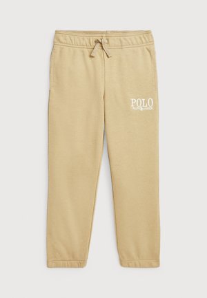 Pantalons de jogging beiges en tissu doux, dotés d'une taille élastique avec cordon de serrage et d'un logo "POLO RALPH LAUREN" blanc sur la cuisse gauche.