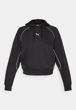Must musta kapuutsiga lühike pluus, millel on valge aksentõmblus ja väike valge logo rinnal. Pehme kangatekstuur.