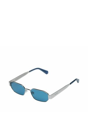 Sonnenbrille mit silbernem Metallgestell, achteckigen blau getönten Gläsern und mit blauem Kunststoff überzogenen Bügelenden.