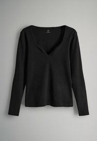 Maglietta nera a maniche lunghe con scollatura a V, realizzata in tessuto a coste, caratterizzata da una vestibilità rilassata e un design minimalista con bordi cuciti.