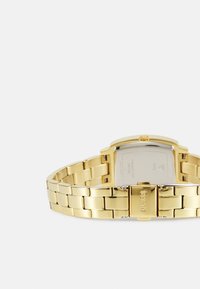Gold metal wristwatch with a rectangular case, link bracelet, and clasp closure. Features a smooth metallic finish and a minimalist design.