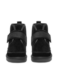 Czarne zamszowe botki za kostkę z regulowanymi paskami, wyściełanym kołnierzem i fakturowanymi gumowymi podeszwami, podkreślające smukły, nowoczesny design.