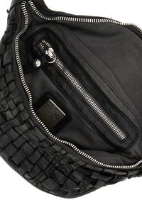 Interno di una borsa nera in pelle con texture intrecciata, dotato di una tasca con zip, fodera in tessuto e un'etichetta metallica. Chiusura con zip superiore.