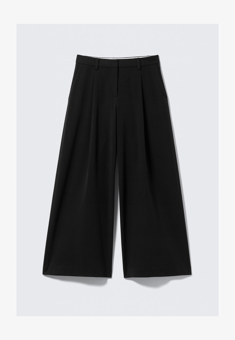 Pantalons larges noirs avec des plis avant, des poches latérales, des passants de ceinture et une fermeture avant cachée sur un fond blanc.