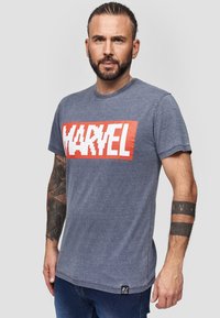 Pánské námořnické modré tričko s velkým bílým logem "MARVEL" na červeném obdélníkovém pozadí. Krátký rukáv a kulatý výstřih. Měkká tkanina.