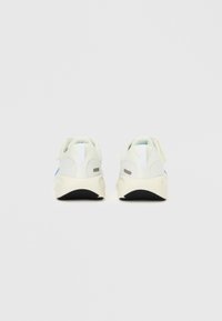 Fehér atlétikai cipők hálós felsőrésszel, kék részlettel kiemelve. Texturált talp fekete gumiból, sarokrésznél húzófüllel.