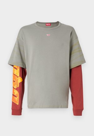Grey short-sleeve t-shirt with a red long-sleeve layer underneath. Features yellow and orange graphic text on the left sleeve.
