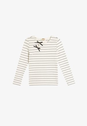 Pitkähihainen valkoinen paita, jossa on mustia vaakasuoria raitoja, pyöreä kaula-aukko sekä kaksi mustaa nauhakoristetta rinnassa.