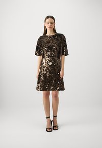 Puku sequins akakora nemapfupi, muBrown yakasviba neCopper, ine relaxed fit uye ine hem refu kusvika pamakumbo. Yakashongedzwa ne sequins inopenya.