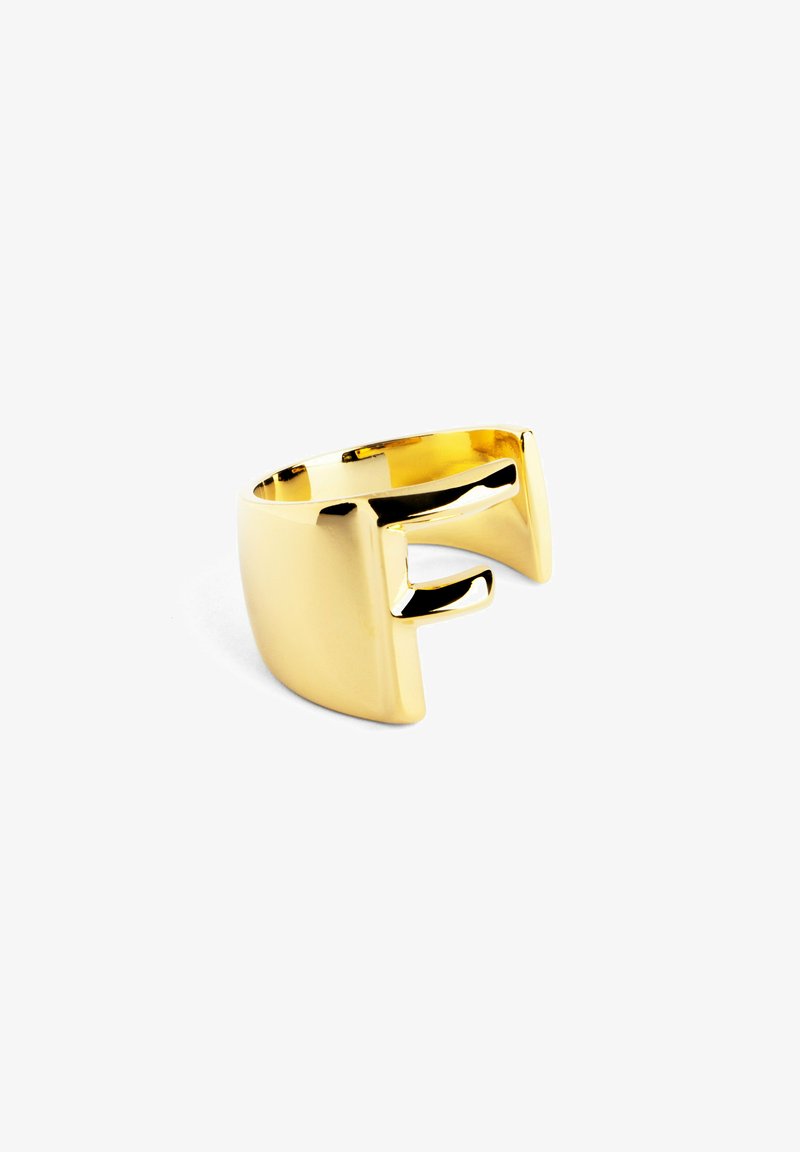 Anillo de oro con un acabado liso y brillante. Presenta un diseño geométrico abierto con un borde inclinado y una pequeña protuberancia como detalle.