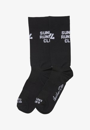 Sorte bomuldssokker med hvid tekst, der læser "SUNDRUN" og "CLI", med en glat tekstur og design i knælængde.