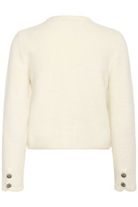 Smetanový svetr s jemným, texturovaným povrchem. Má dlouhé rukávy a dvě knoflíkové ozdoby na každém manžetu. Jednoduchý kulatý výstřih.