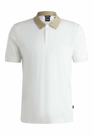 Vit polo skjorta med en beige stickad krage, två-knappars stolpe, korta ärmar och en liten logotag vid nederkanten. Slät tygtextur.