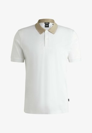 Polo bianco con colletto in maglia beige, patta con due bottoni, maniche corte e una piccola etichetta con logo sull'orlo. Tessuto dalla texture liscia.