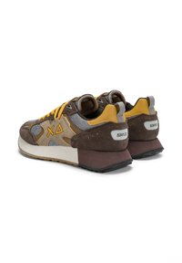 Baskets marron et grises avec des lacets jaunes, matériaux en daim et en maille, design à profil bas, forme de talon unique et accents de logo à l'arrière.
