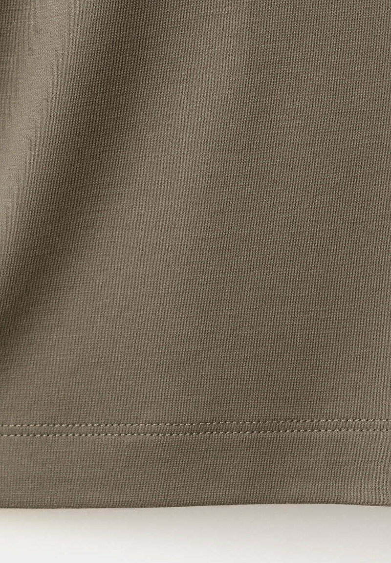 Close-up of brown fabric with visible stitching along the hem, showing a smooth texture and slight shadow from fabric folds.