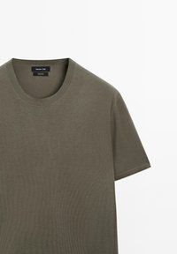 Olivově zelené krátké rukávy bavlněné tričko s kulatým výstřihem od Massimo Dutti, zobrazené na čistém bílém pozadí.