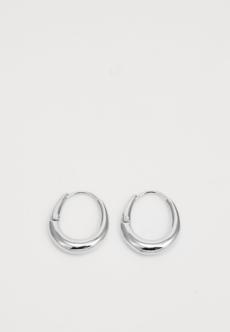 Hõbedased rõngas kõrvarõngad, millel on sile ja läikiv viimistlus. Need on ümmarguse kujuga ja lihtsa klambri disainiga, mis tagab kindla kandmise.