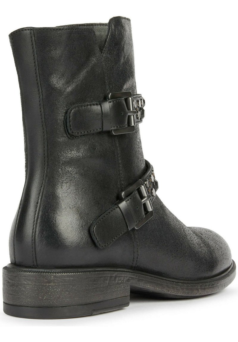 Bottine en cuir noir avec deux sangles décoratives en boucle et un petit talon empilé, vue de l'angle arrière.