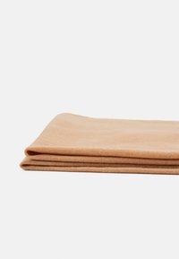 Tissu pêche clair plié avec une texture douce, fabriqué en matière tricotée, présentant des bords nets et une finition lisse.