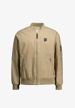 Cazadora bomber de color beige claro con cierre frontal de cremallera, puños acanalados y dos bolsillos laterales con cremallera. Presenta un pequeño logo en el pecho izquierdo.