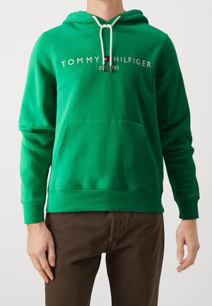 Sudadera verde con capucha hecha de tela suave, que incluye un bolsillo frontal, capucha con cordón ajustable y logo bordado de "Tommy Hilfiger" con la fecha de establecimiento.