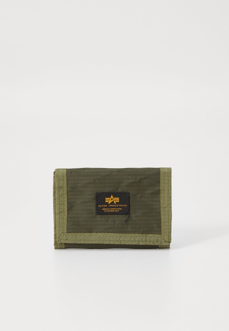Portefeuille vert olive fabriqué en nylon résistant, présentant une forme rectangulaire, des bords cousus et une étiquette noire avec un texte jaune.