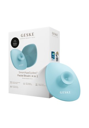 Brosse faciale en silicone bleue avec support ventouse à côté de son emballage blanc étiqueté "SmartAppGuided Facial Brush 4 in 1" par GESKE.