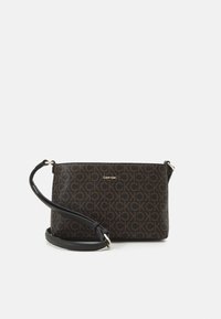 Crossbody taška Calvin Klein v černé umělé kůži, s hnědým vzorem loga, zlatými kovy a nastavitelným popruhem.