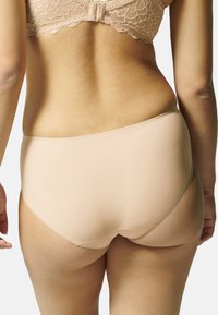 Nude wysokoskalowe majtki wykonane z gładkiego materiału, z bezszwowym wzornictwem i subtelnymi detalami szwów w pasie.