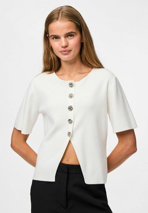 Cárdigan blanco de manga corta con cuello redondo y cinco botones metálicos decorativos, con un diseño de abertura frontal y textura suave.
