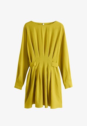 Dzelteni sinepju krāsas garām piedurknēm kleita ar krokotu vidukļa detaļu, apaļu kakla izgriezumu un piegulošām aprocēm, attēlota uz balta fona.