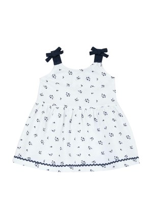 Abito bianco con piccola stampa floreale blu navy, spalline blu navy con fiocchi, vita arricciata e orlo con pizzo ondulato bordato in blu navy.