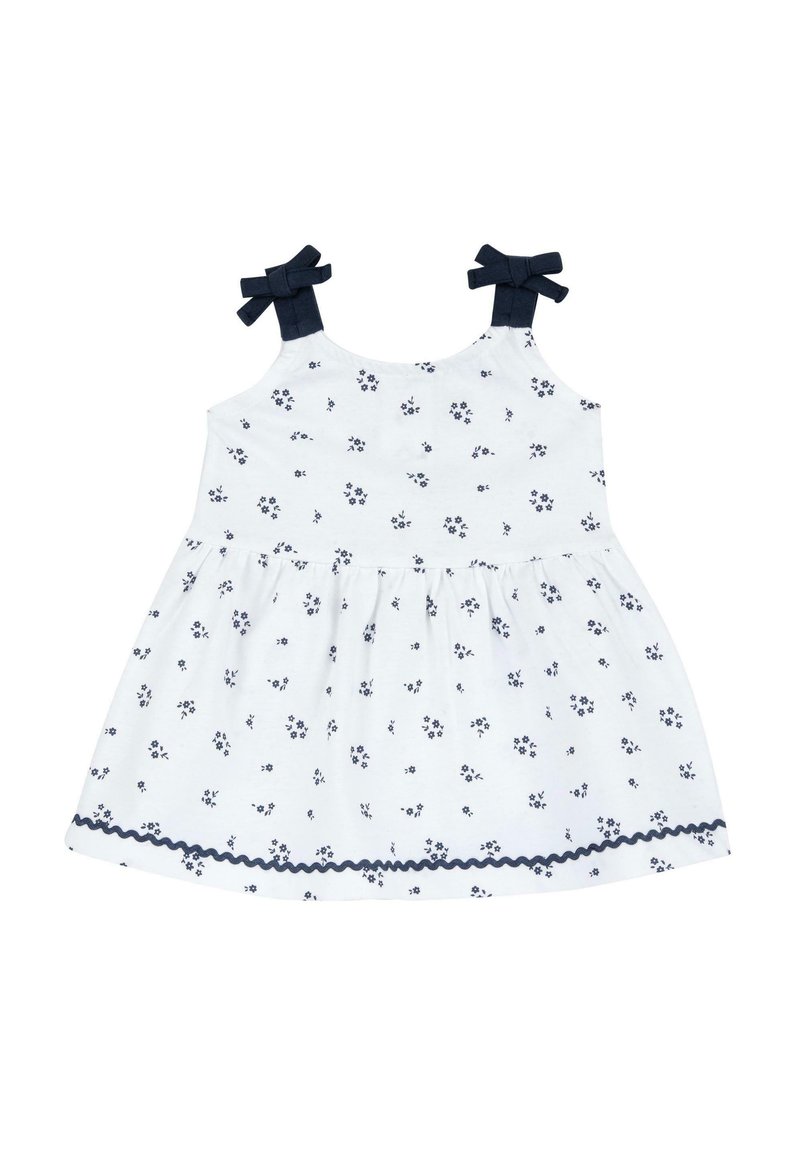 Robe blanche avec un petit imprimé floral bleu marine, bretelles bleu marine avec des nœuds, taille froncée et un ourlet à volants bordé de bleu marine.