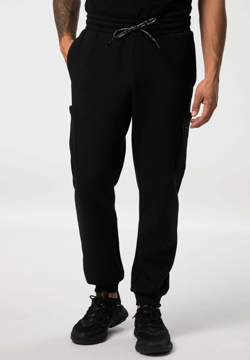 Schwarze Jogginghosen aus weichem Material, mit einem elastischen Taillenbund mit Kordelzügen, seitlichen Taschen und gerippten Bündchen.
