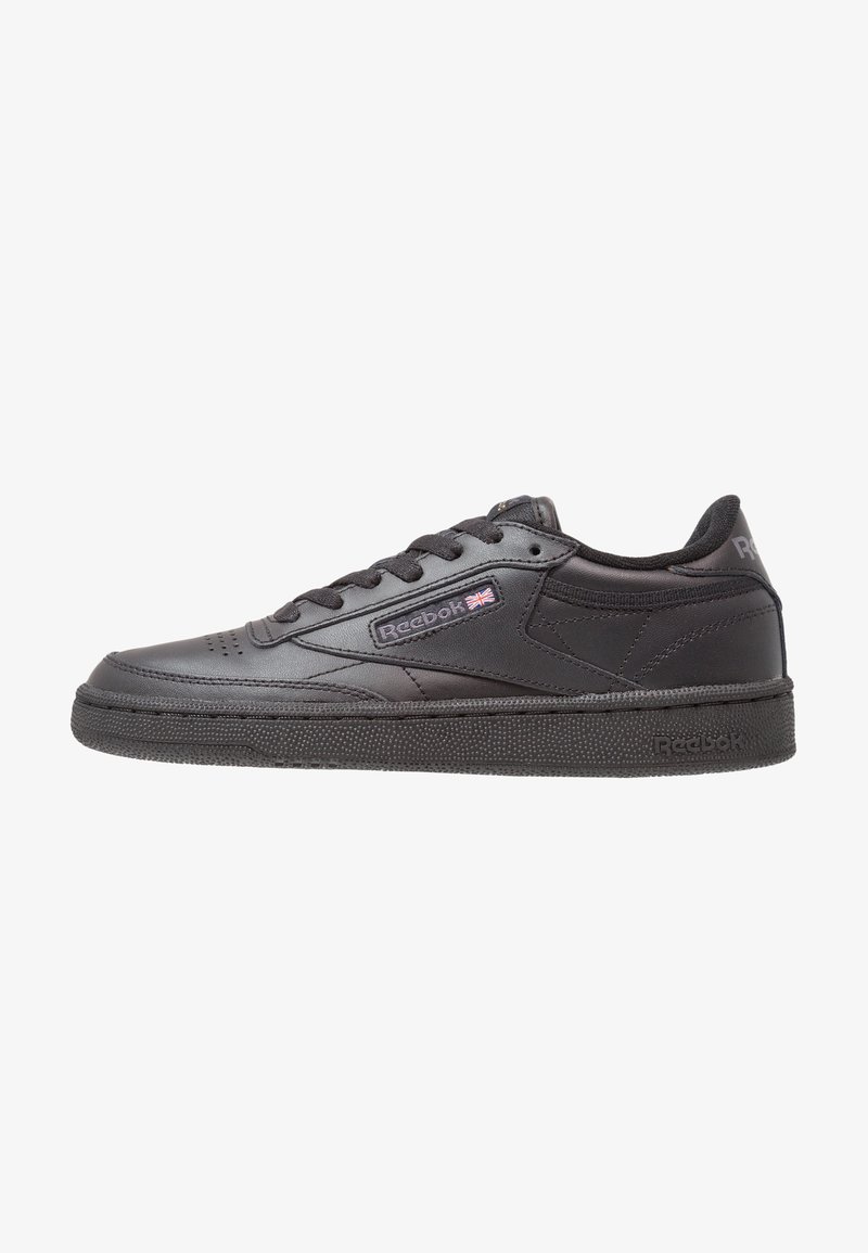 Baskets basses noires Reebok avec laçage à l'avant, semelle texturée et petit logo Union Jack sur le panneau latéral.