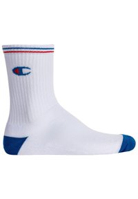 Weiße Sportsocke mit geripptem Muster, blauen Akzenten an Zehen und Ferse sowie einem gestickten Logo in Blau und Rot nahe der Oberkante. Standard Crew-Höhe.