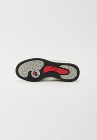 Fehér sneaker talp fekete és szürke tapadásmintával, piros kiegészítővel és logó részlettel. Kiemelkedő jellemzője a strapabíró szürke felszín a jobb tapadás érdekében.