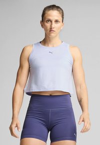 Svetle fialový krátký top s malým logem, ve spojení s tmavě modrými kraťasy s vysokým pasem. Hladká tkanina a přiléhavý střih.