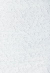 Weißer Spitzenstoff mit floralem Muster, der eine filigrane Textur und variiert dicke Fäden aufweist, geschichtet für Tiefe und Weichheit.