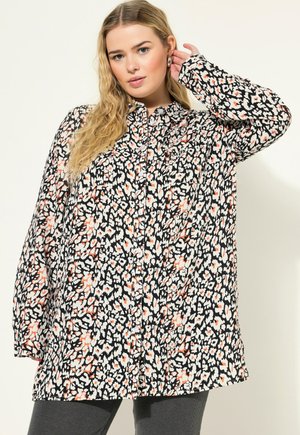 Lange button-up blouse met een zwart, wit en koraalkleurig bloemenpatroon, voorzien van een kraag en lange mouwen. Zachte stof met een relaxte pasvorm.