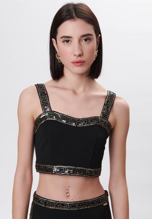 Schwarzes, kurz geschnittenes Top mit aufwendigen, golden bestickten Trägern und Besätzen. Verfügt über ein figurbetontes Design und eine glatte Textur.