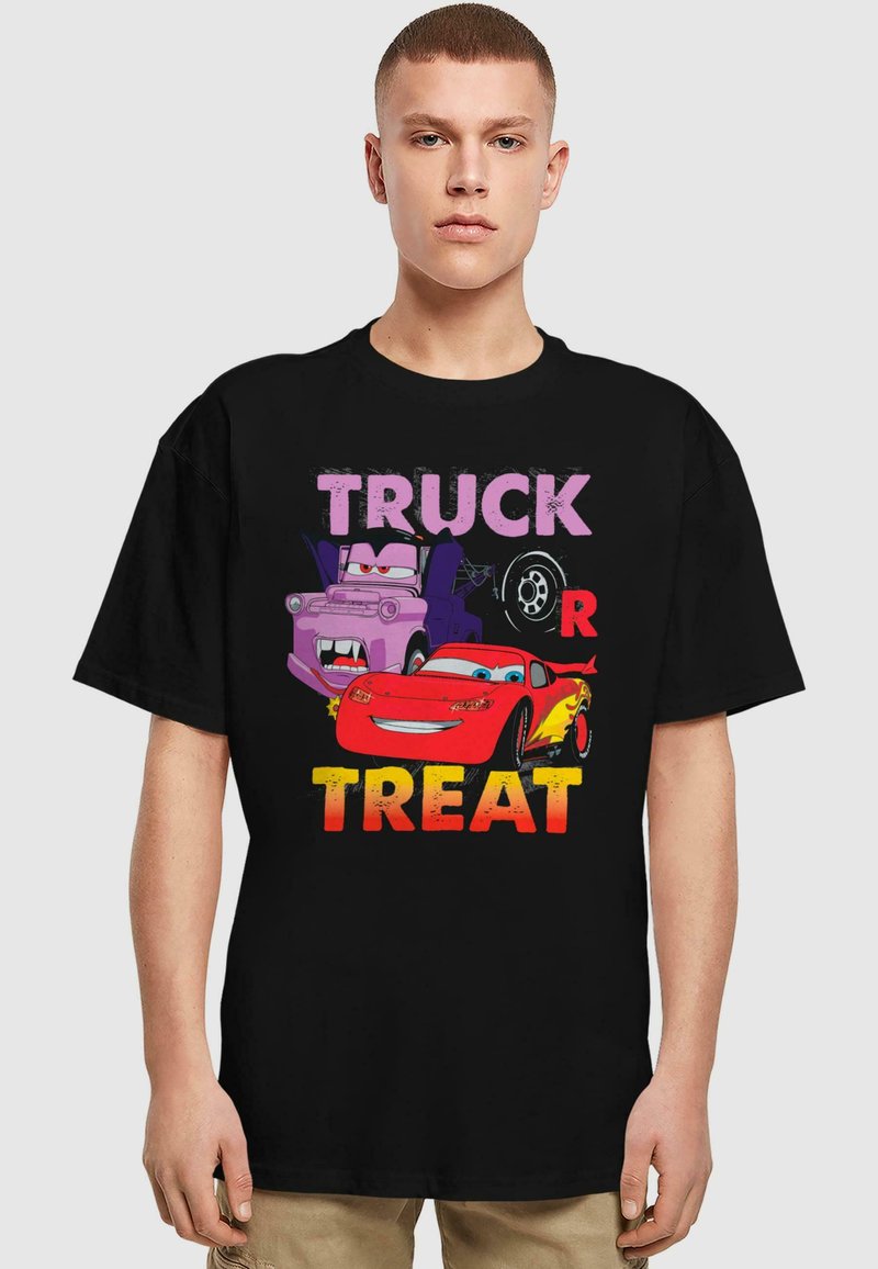 Must venitus musta T-särk, millel on koomiksite autod ja julge tekst "TRUCK OR TREAT" erkkollastes värvides. Kangelased on lilla veok ja punane auto.