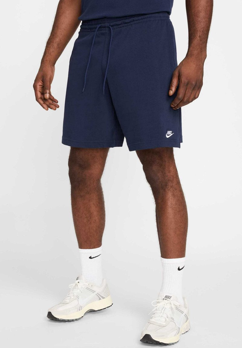 Shorts deportivos azul marino con cintura elástica y cordón ajustable. Pequeño logo blanco de Nike en la pierna izquierda. Fabricados con un tejido suave y ligero.