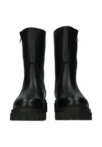 Botas de tobillo de cuero negro con una textura suave, presentan una punta redonda y cremallera lateral, y tienen una suela de goma gruesa y con patrón.